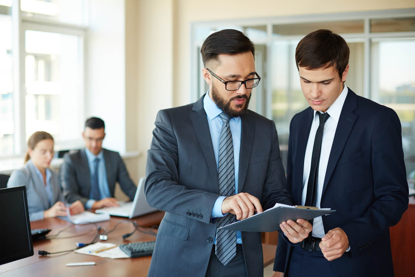 Business professionals discussing documents in an office setting, emphasizing collaboration and communication in a corporate environment related to crypto gambling disclosures.